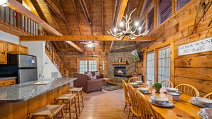 Interior rústico de una cabaña con cocina, comedor y sala de estar.