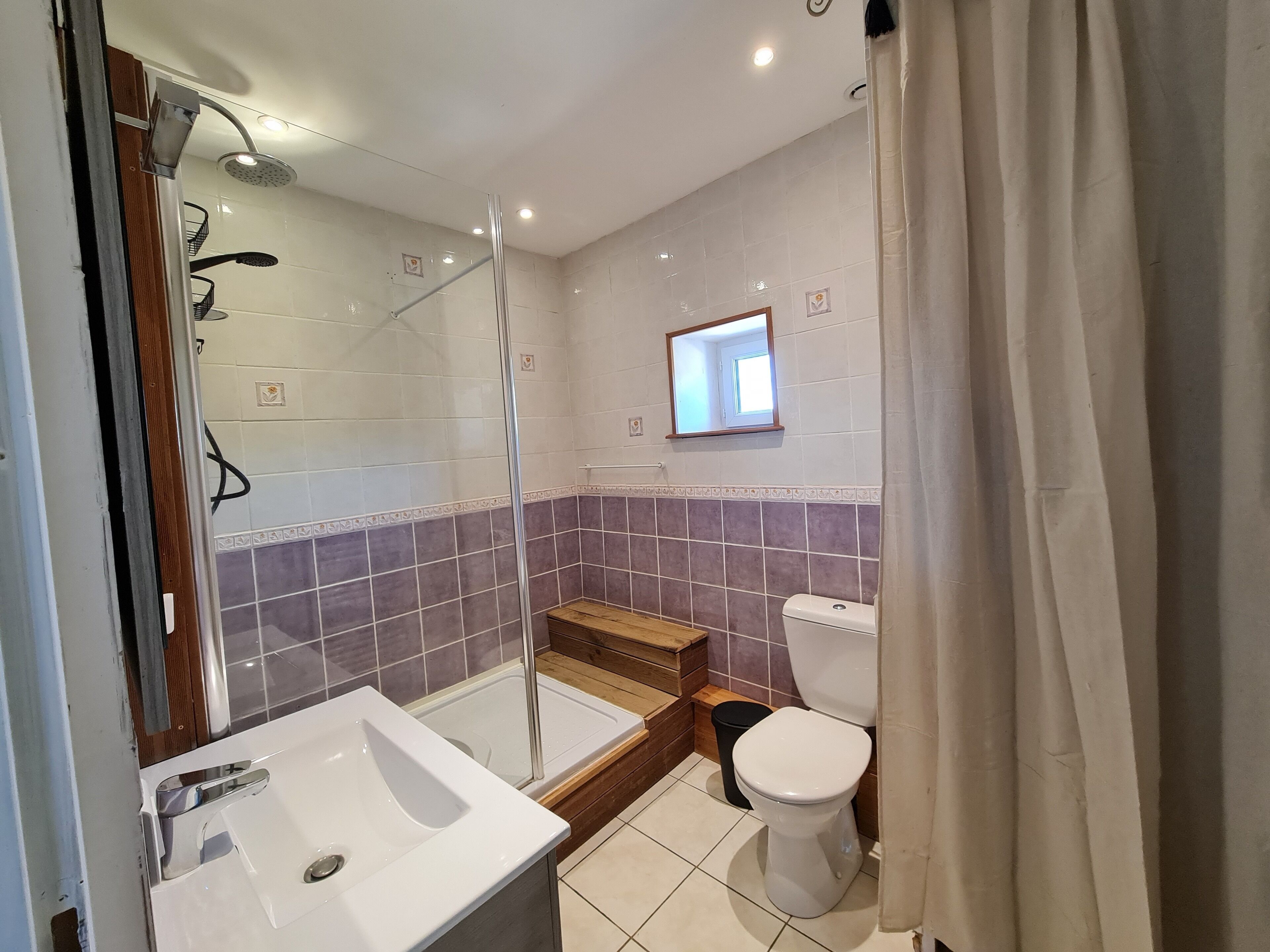 A bathroom with a shower, toilet, and sink.