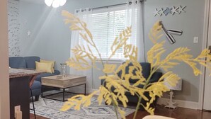 A living room with a blue sofa, a coffee table, and a decorative plant.
