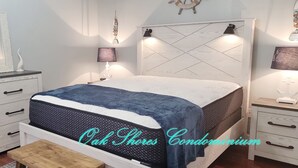 A bedroom with a bed, a dresser, a nightstand, and a bench.