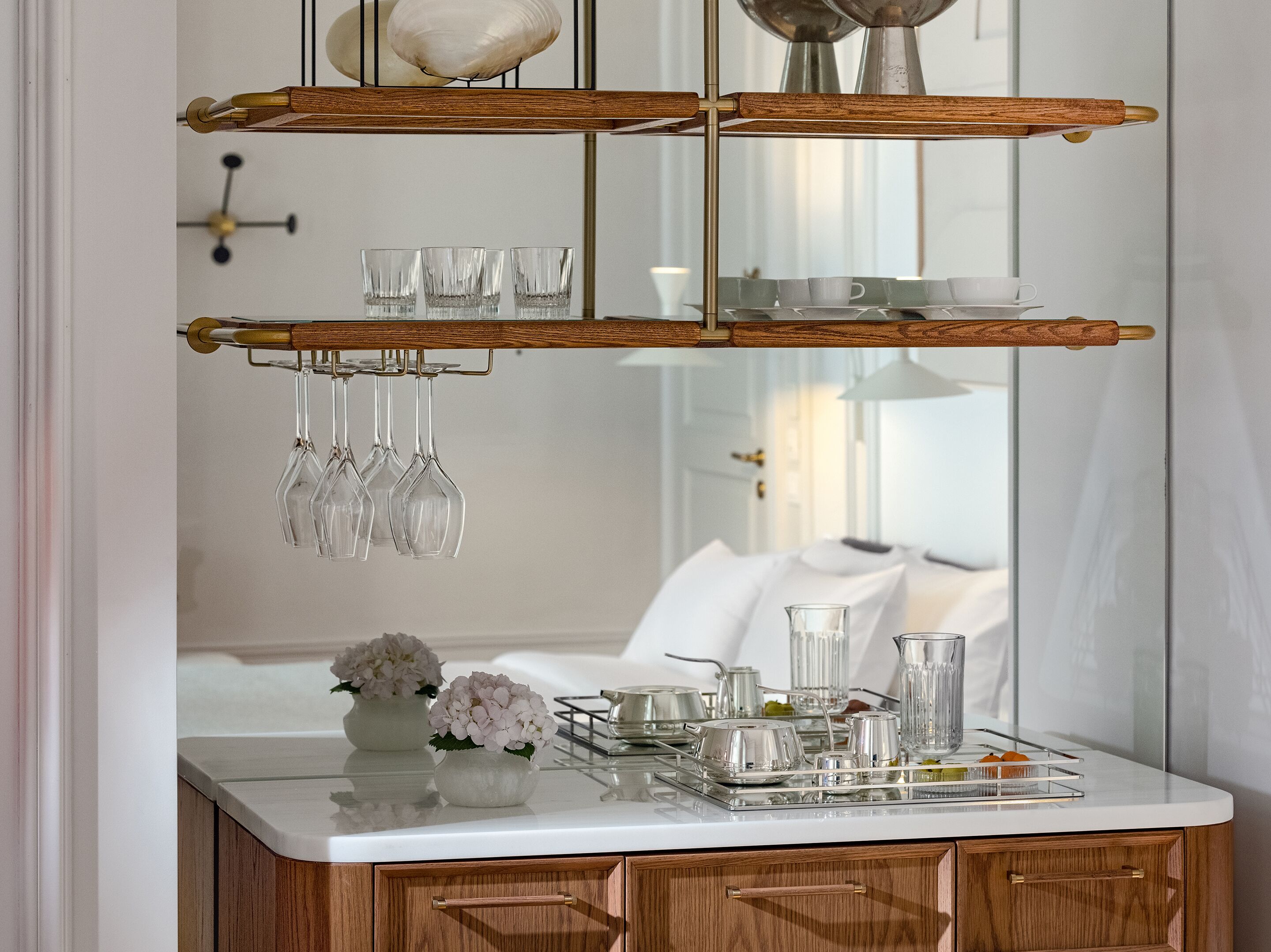 A modern kitchen with a white countertop, wooden cabinets, and a mirrored backsplash.