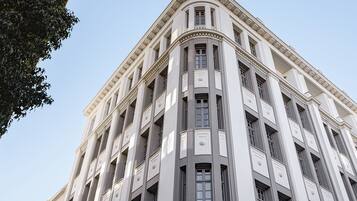 Un immeuble à étages, de style architectural classique, caractérisé par une façade symétrique, de grandes fenêtres et des moulures décoratives.