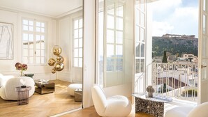 Una habitación amplia con un espejo grande, vistas a un paisaje urbano y un sofá blanco moderno.