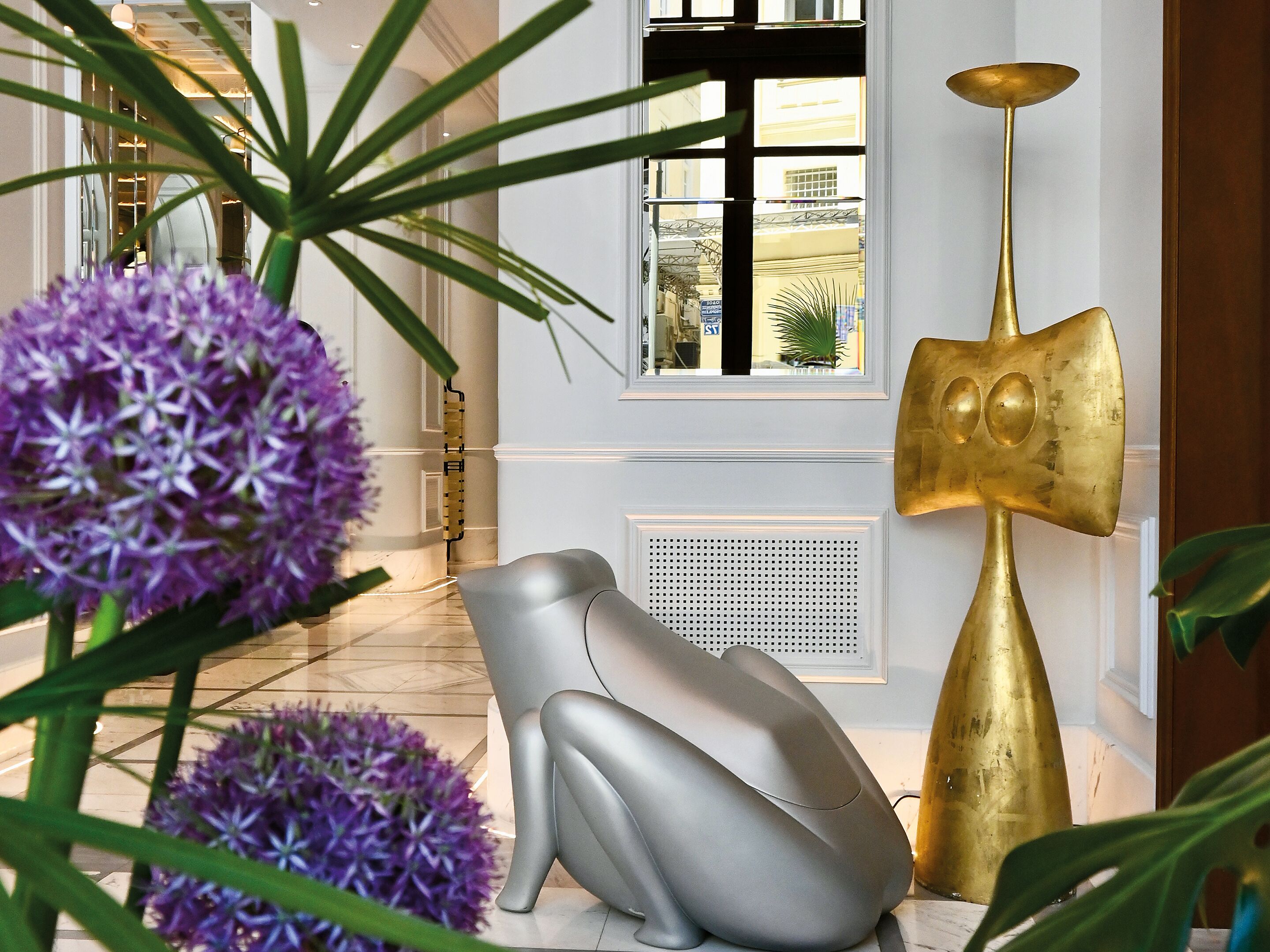 Um interior moderno com uma escultura decorativa, uma luminária única e vista pela janela.