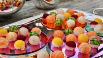 Diversos pedaços de sushi colorido dispostos em pratos de vidro.