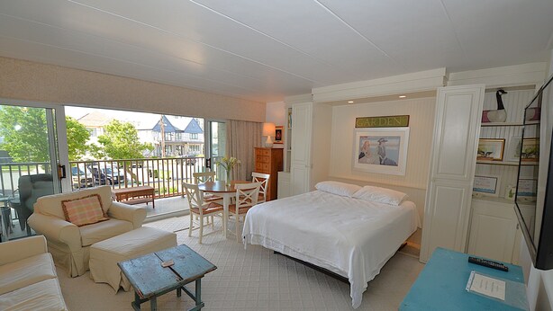 Une chambre d’hôtel avec un lit, un canapé, une table et un balcon donnant sur l’extérieur.