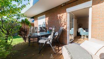 Eine Terrasse mit Tisch und Stühlen, einer Sitzecke und einer Ziegelwand.