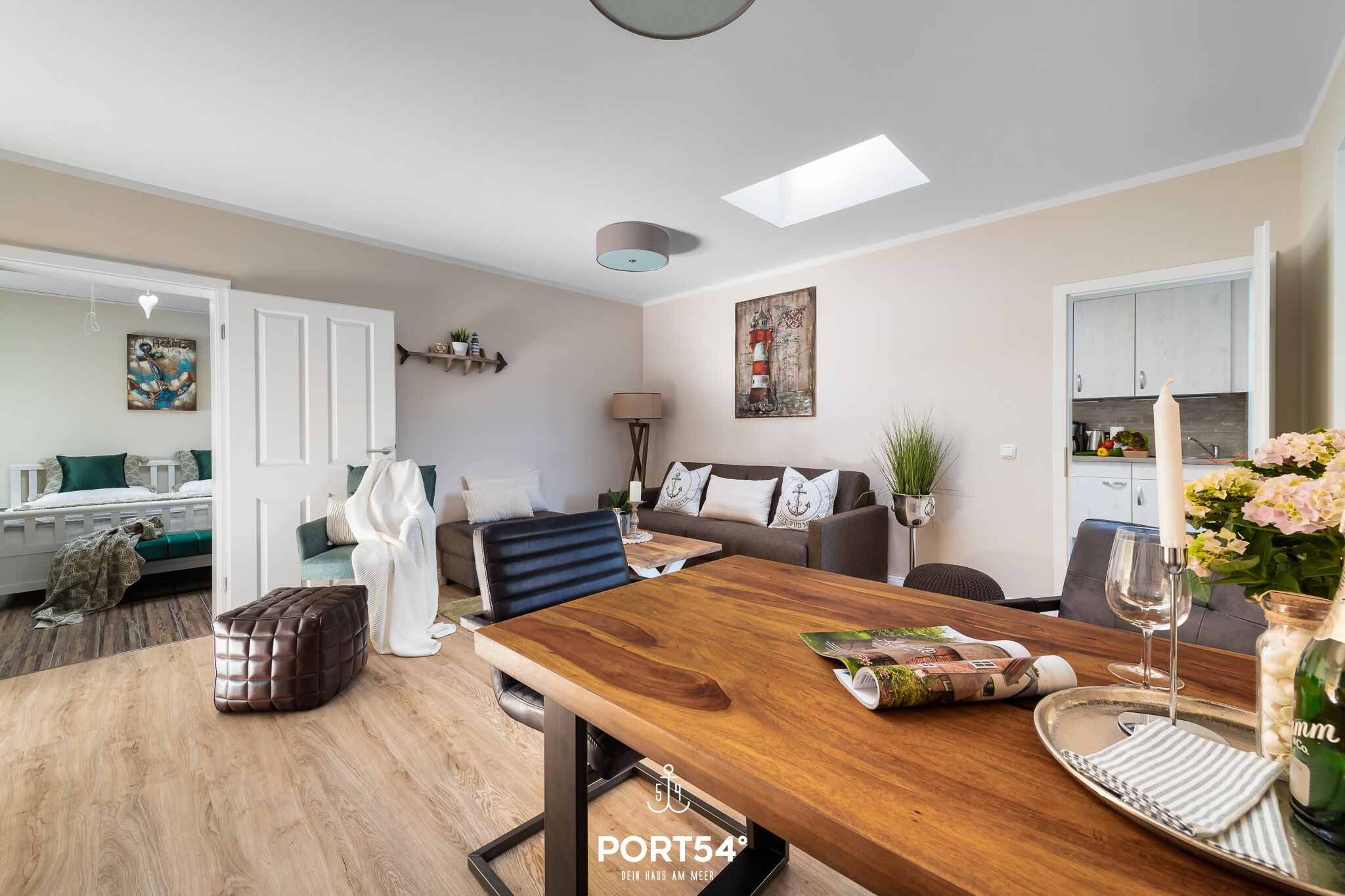 Un salon moderne avec une table à manger en bois, un canapé et une cuisine en arrière-plan.