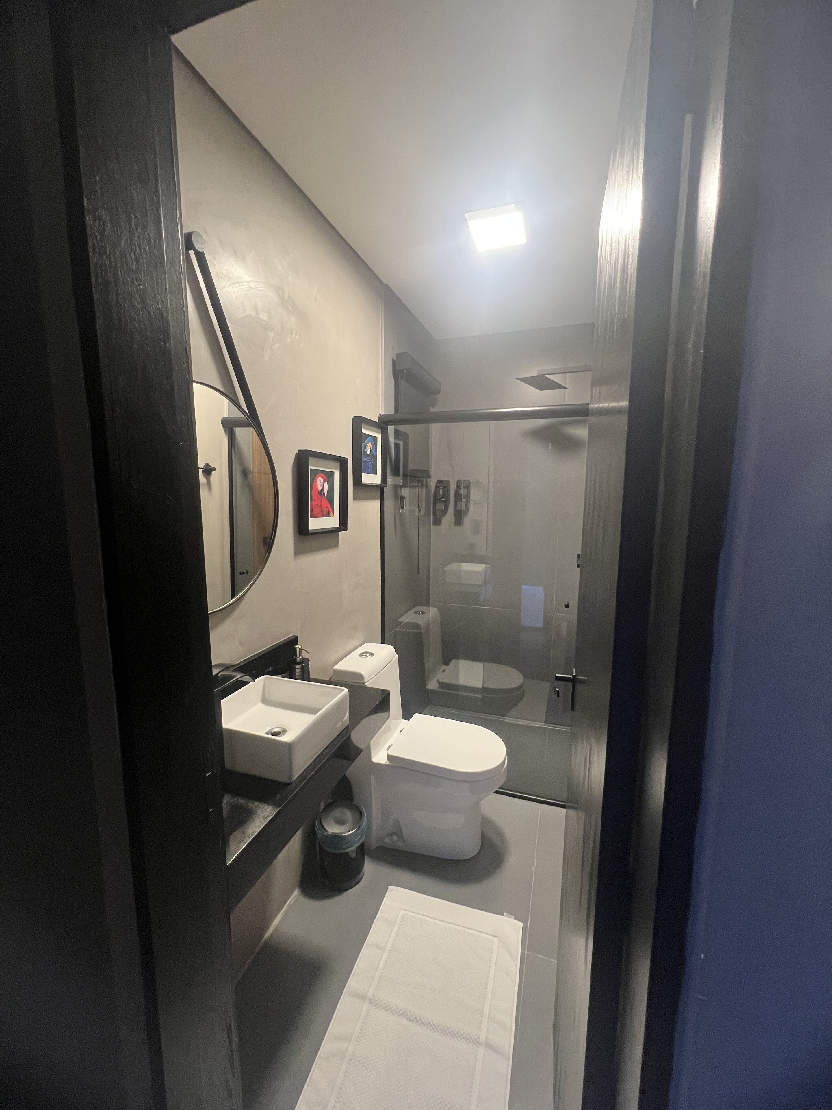 A modern bathroom with a sink, toilet, and glass-enclosed shower.