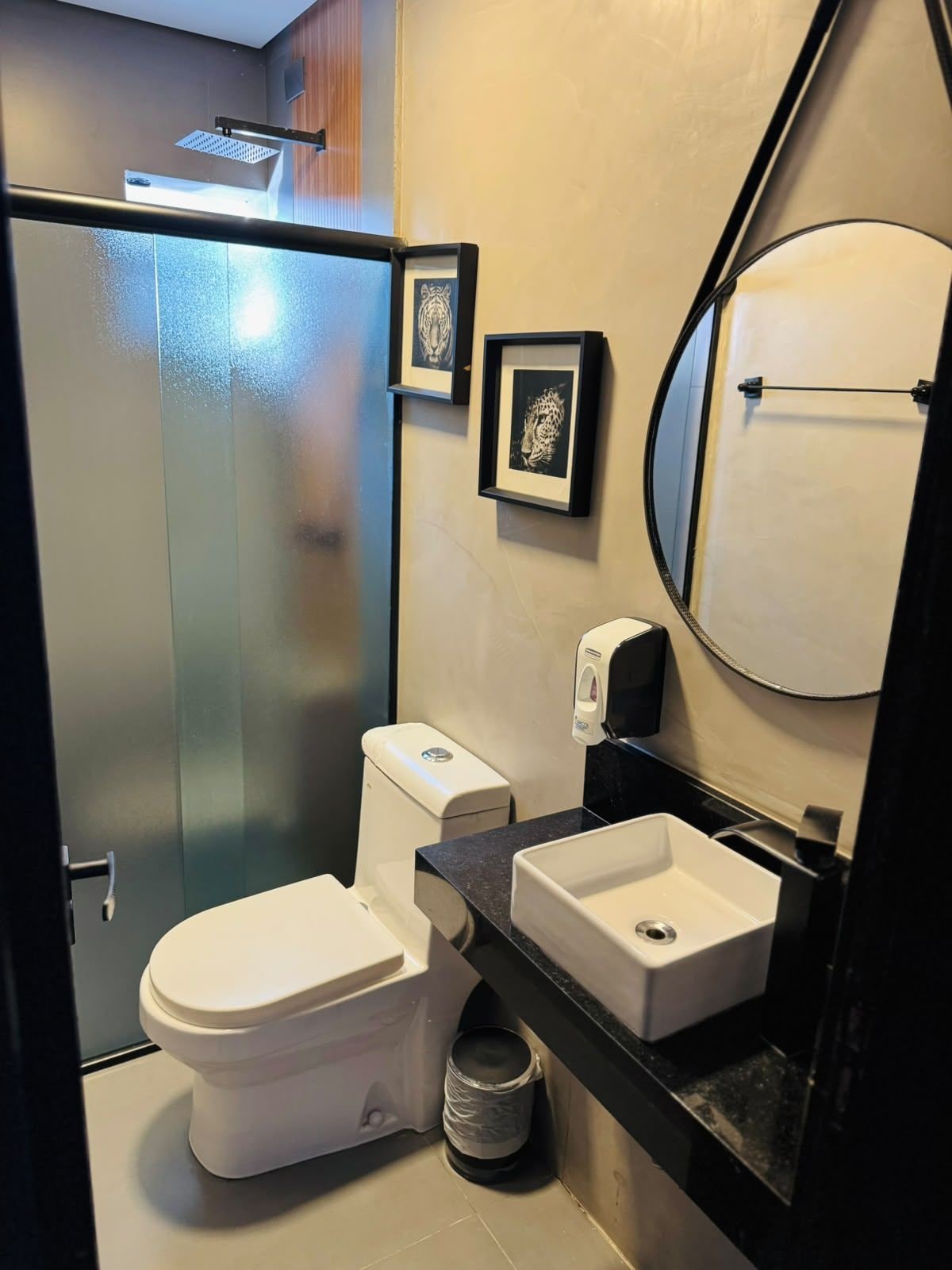 A modern bathroom with a toilet, sink, and shower.