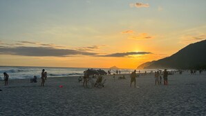 A beach with people, umbrellas, and beach chairs. - Hotel la serena (Sao Sebastiao)