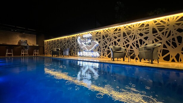 A pool area with a sign for 'Hotel La Serena' and a decorative wall. - Hotel la serena (Sao Sebastiao)