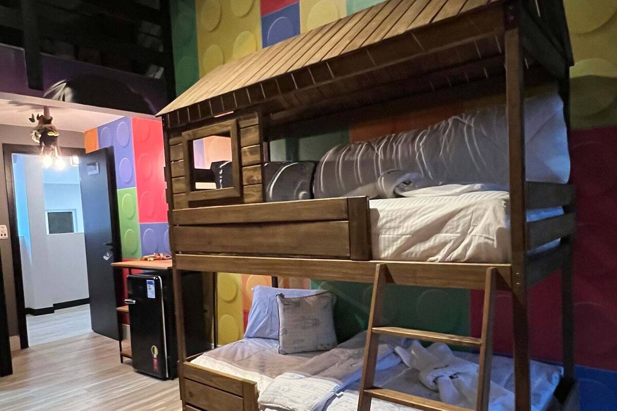 A bunk bed with a wooden frame and a colorful wall behind it.