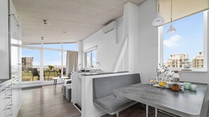 Une cuisine moderne avec un coin repas, de grandes fenêtres et une vue sur le paysage urbain.