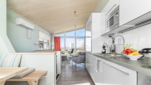 A modern kitchen with a built-in microwave, a sink with a faucet, and a countertop with fresh vegetables.