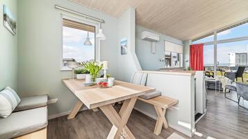 Una cocina moderna con una mesa de madera, un banco y vistas a la ciudad.