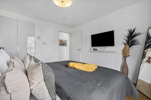 A bedroom with a bed, a television, and a door. - Hollywood Lounge - Infrared Sauna, Fireplace, Parking Space, EV Charging Station (Olpenitz)