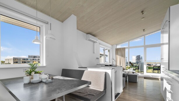 Una cucina moderna con zona pranzo, ampie finestre e vista sul mare.