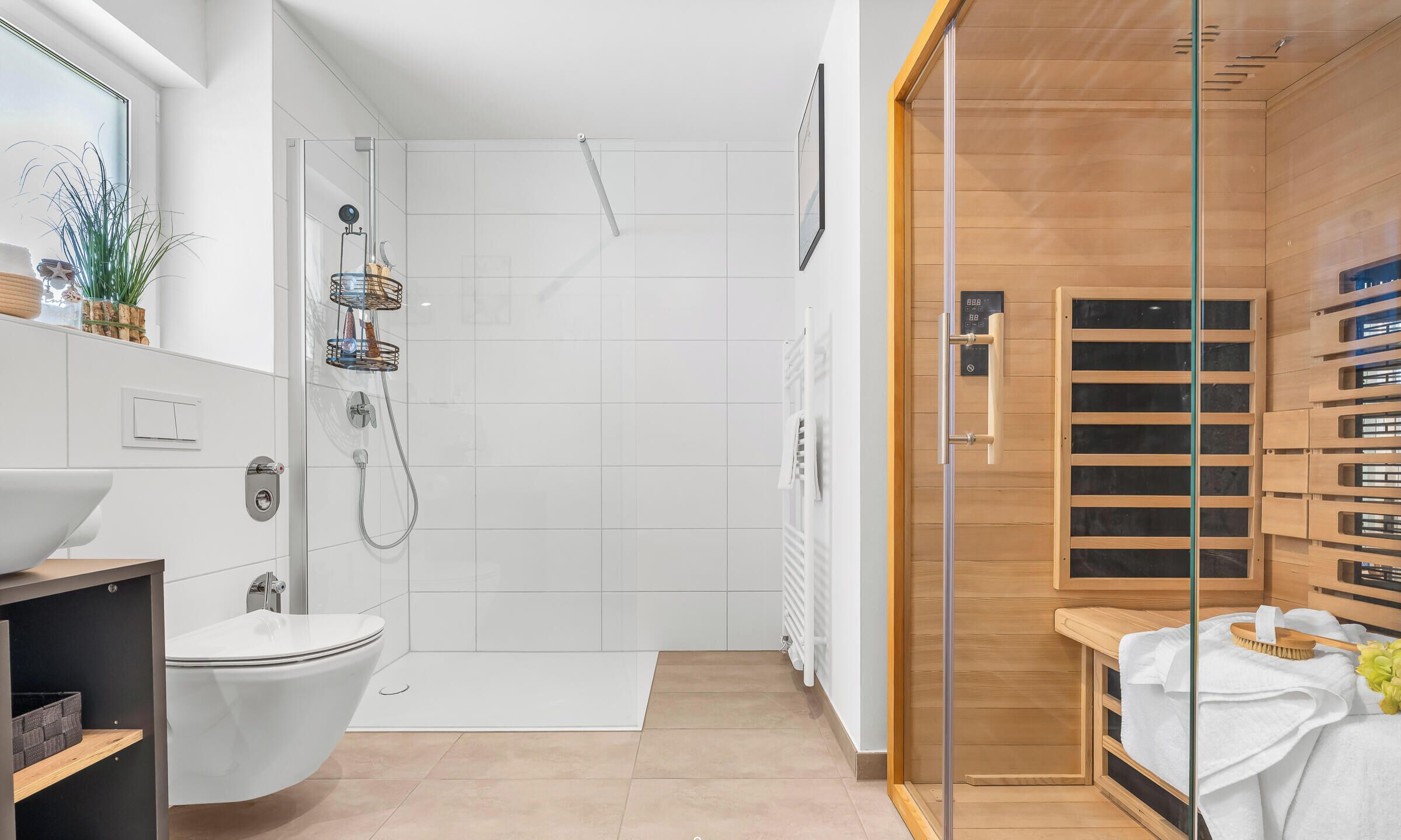 A modern bathroom with a shower, toilet, and a glass-enclosed sauna area.