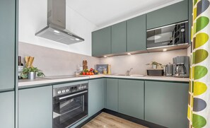 Uma cozinha moderna com forno Bosch, cafeteira e pia.