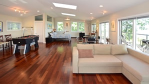 A spacious living room with a foosball table, a sofa, and a dining area with a table and chairs. - Unequalled Views of Reservoir & Mtns, Affordable, Totally Private (West Hurley)