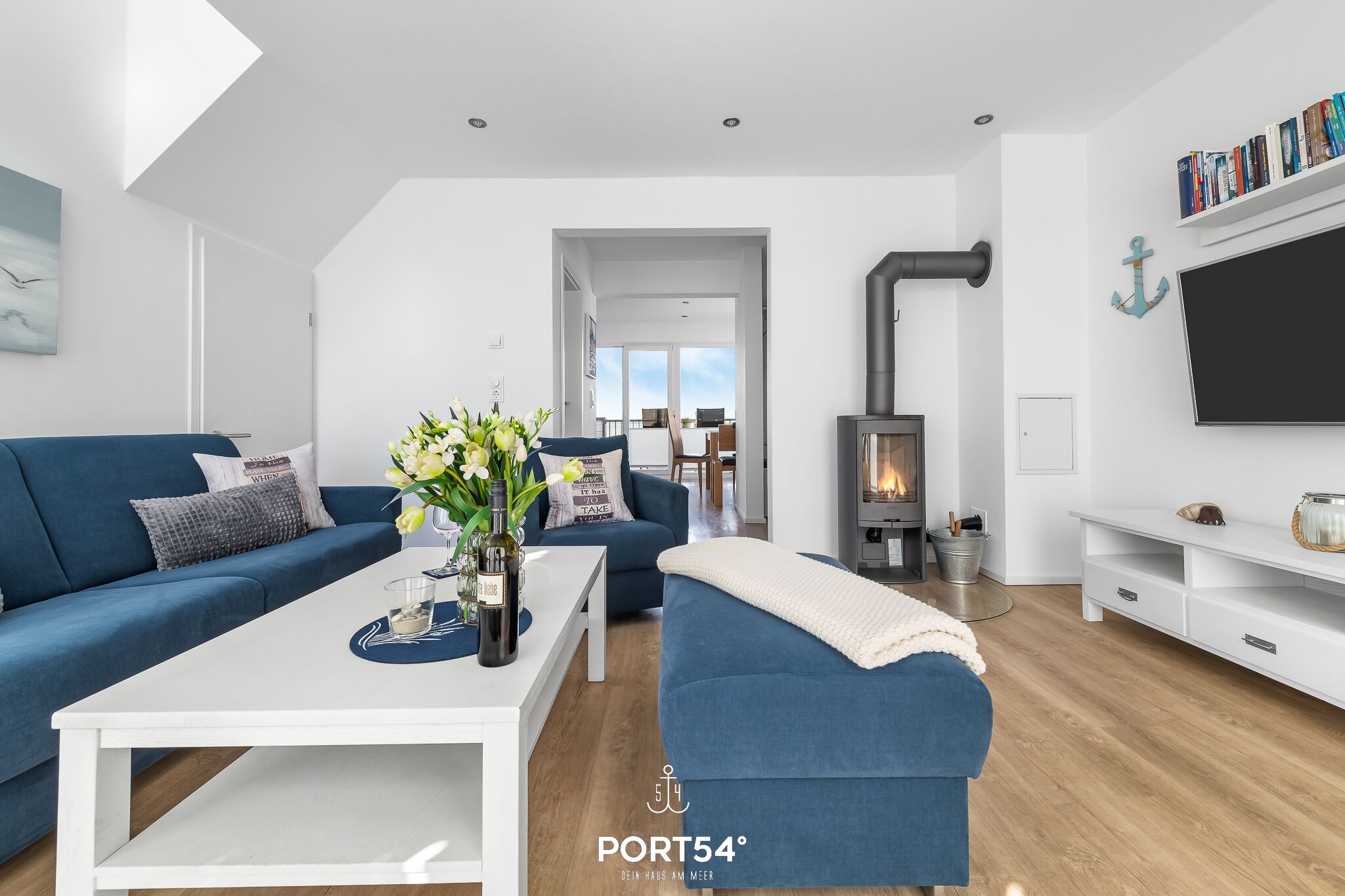 A modern living room with a blue sofa, white coffee table, and a fireplace.