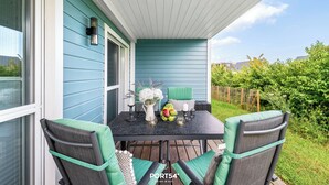 Eine Terrasse mit Tisch für zwei Personen, Außenbeleuchtung und Blick auf die Umgebung.