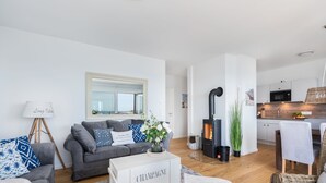 Una sala de estar moderna con un sofá gris, un espejo y una chimenea.