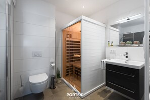 A modern bathroom with a toilet, sink, and a walk-in closet with sliding doors.
