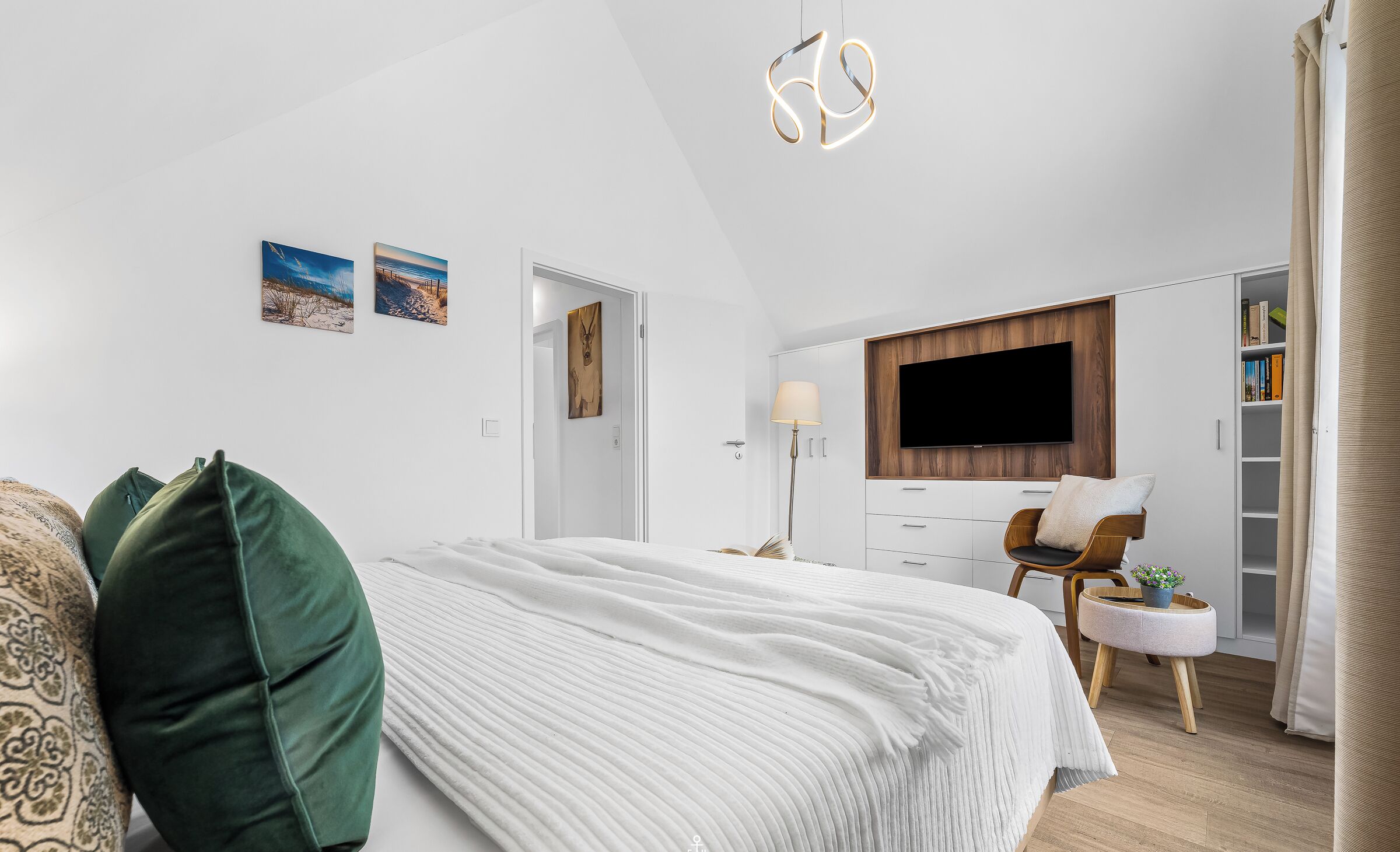 Une chambre à coucher moderne, équipée d’un lit, d’une télévision, d’un bureau et d’une bibliothèque.