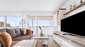 Ett modernt vardagsrum med en soffa, ett soffbord och ett TV-bord.