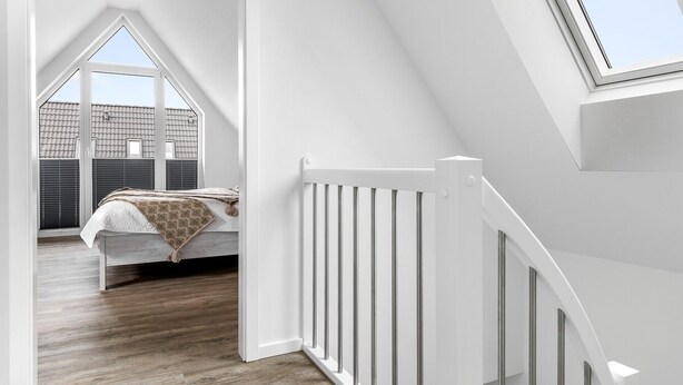 A modern loft bedroom with a sloped ceiling, a skylight, and a view of the roof. - Coast 8 - 2 bedrooms, shower room, balcony, stylishly furnished (Westerdeichstrich)