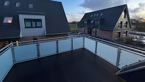 A modern residential building with a flat roof and a balcony with a glass railing. - Coast 8 - 2 bedrooms, shower room, balcony, stylishly furnished (Westerdeichstrich)