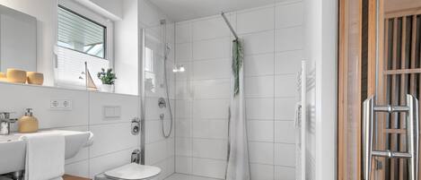 Ein modernes Badezimmer mit Dusche, Toilette und Waschbecken.