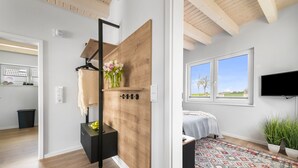 Un dormitorio moderno con cama, televisión y vistas al exterior.