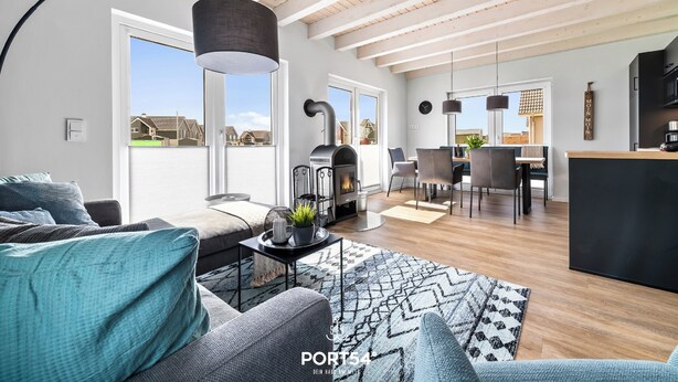 Una sala de estar moderna con chimenea, un comedor y una cocina.