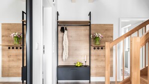 Un interior moderno con suelo de madera, un banco negro y una escalera de madera.