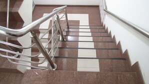 Una escalera con barandillas de metal y un piso con diseño de cuadros.