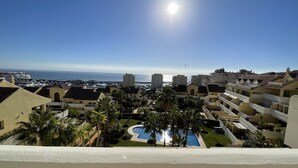 A residential area with a pool, palm trees, and a view of the sea. - Fantastic sea views! Close to the beach apartment (Estepona)