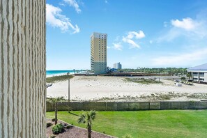 Un hôtel de grande hauteur donnant sur une plage, avec un ciel dégagé.