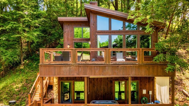A multi-level wooden cabin with large windows, a deck, and a hot tub. - King beds, quiet neighborhood. Hot tub, games & fire pit! 5 mi to Dollywd.  (Sevierville)