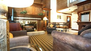 A spacious living room with a fireplace, comfortable seating, and a dining area. - Sunburst Condominiums (Steamboat Springs)
