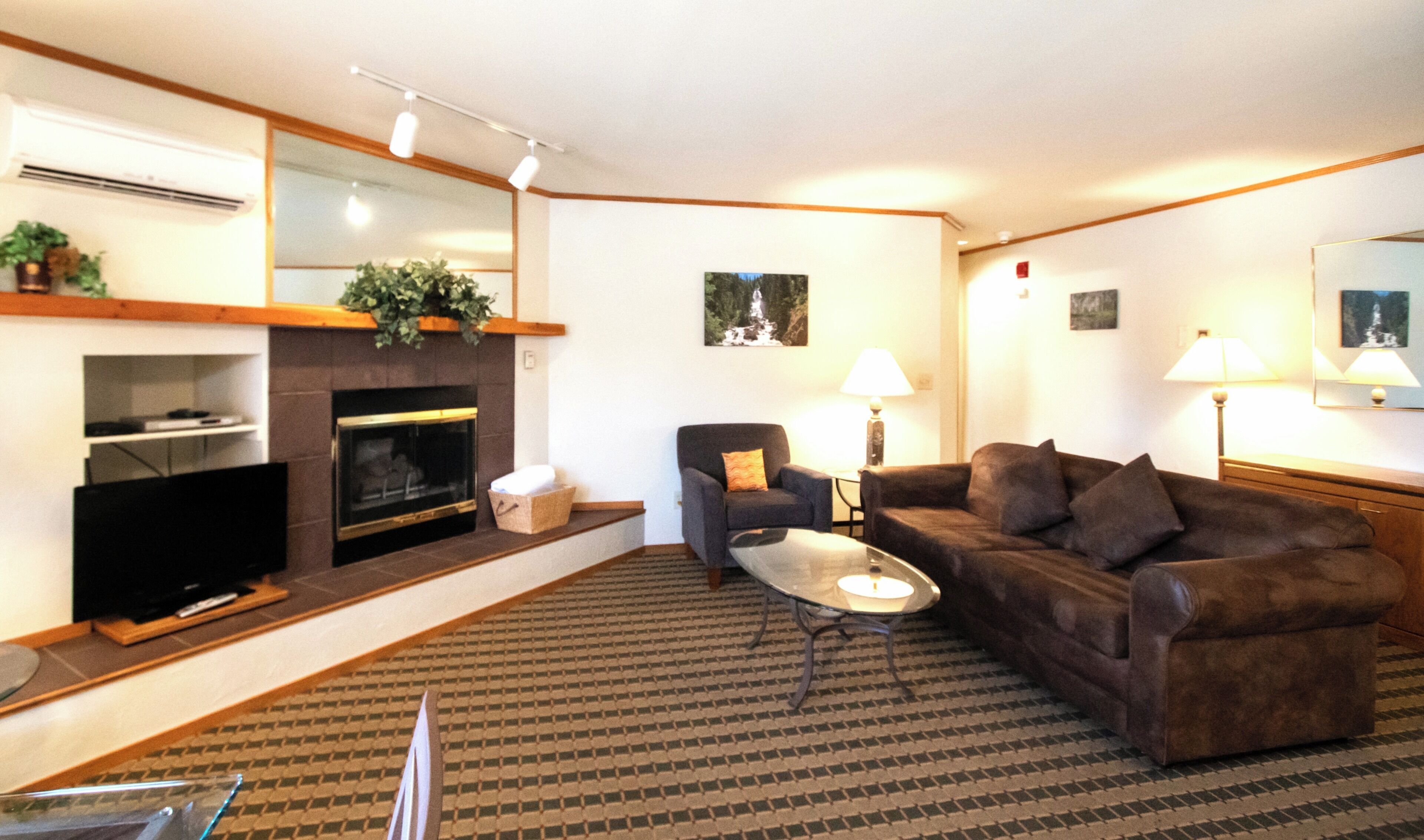 A living room with a fireplace, a sofa, a coffee table, and a television.