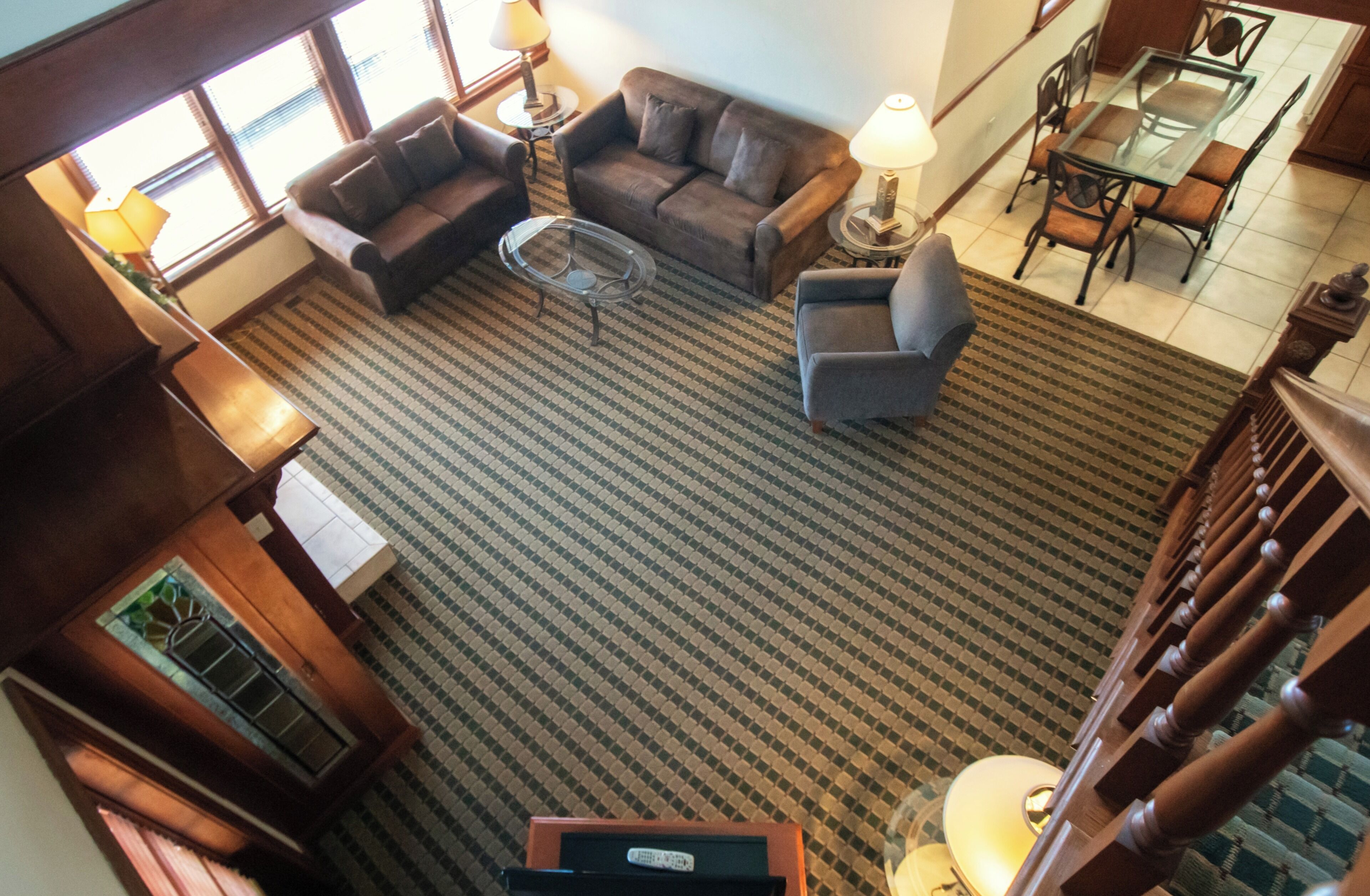 Un vaste espace de vie comprenant un tapis à motifs, un canapé, une table basse et une table à manger avec des chaises.