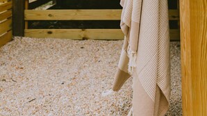 A wooden outdoor shower area with a towel hanging on a rack. - Canal front, Modern Tiny House! Bikes. Fire pit! (Kitty Hawk)