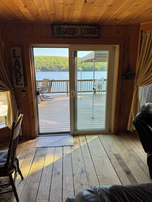 Eine Holzhütte mit einer Terrasse mit Blick auf einen See.