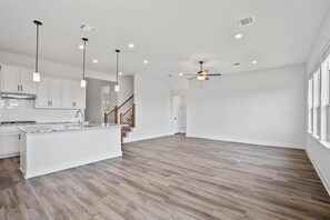 Enjoy cooking in this well-equipped kitchen with a central island, stainless steel range hood, and sink.