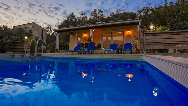 Una piscina con sillas de descanso y una zona de estar techada.