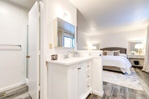 Relax in a serene space with a large bed, vanity, and lamp.