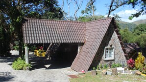 Een rustiek stenen gebouw met schuine dak en een verharde opgang.